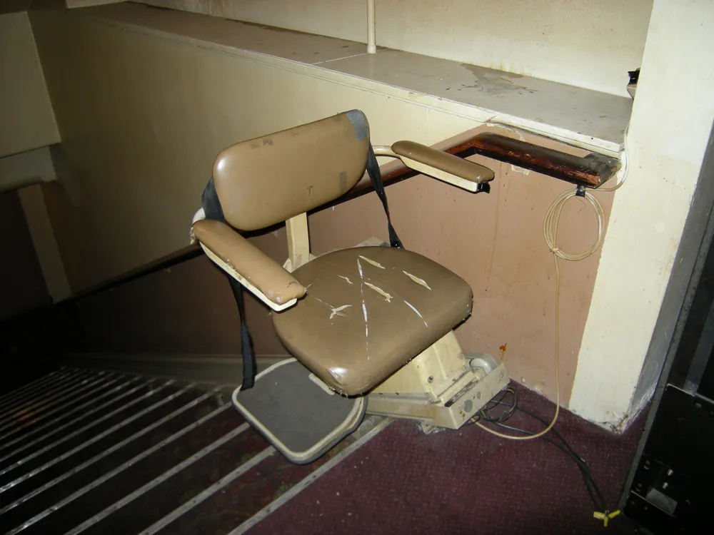 A stairlift installed at the top of a staircase, showing how it looks on the landing