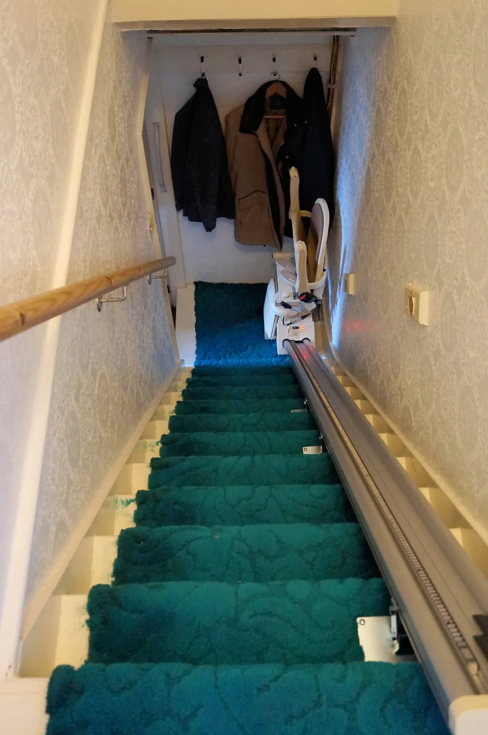 A stairlift installed on a straight staircase in a UK terraced house