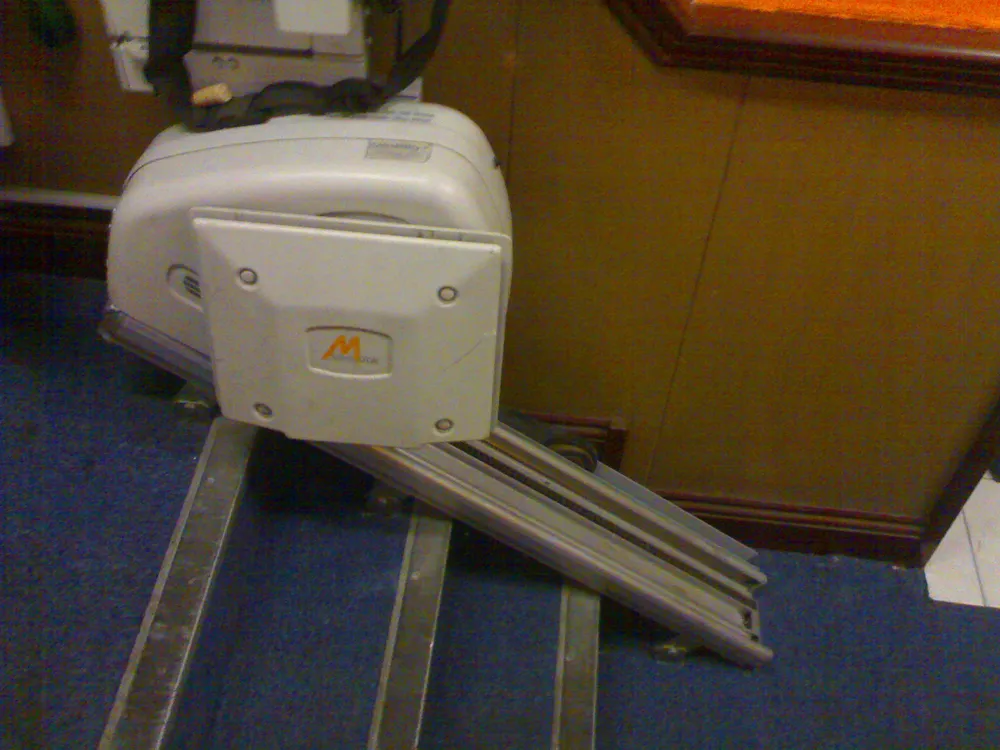 A stairlift chair and rail system installed on a residential staircase